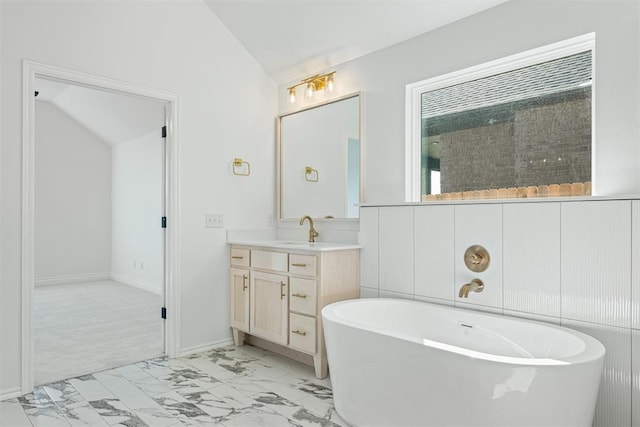 bathroom with vanity, lofted ceiling, and a bath