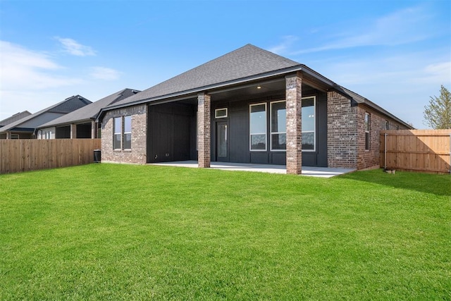 back of house with a lawn and a patio area