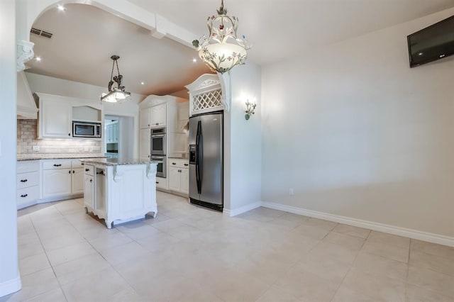 kitchen featuring white cabinetry, stainless steel appliances, tasteful backsplash, light stone counters, and a kitchen island