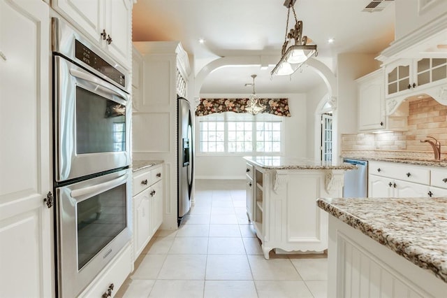 kitchen with white cabinets, decorative light fixtures, tasteful backsplash, and sink