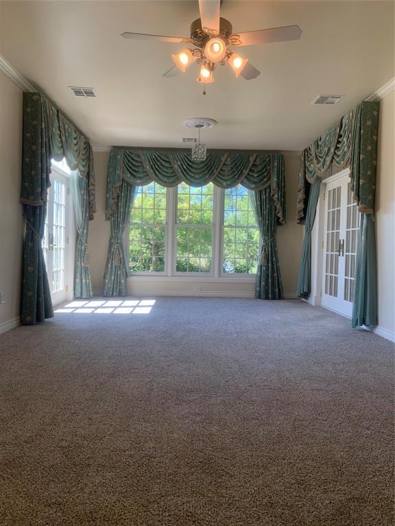 carpeted spare room featuring french doors, ceiling fan, and ornamental molding