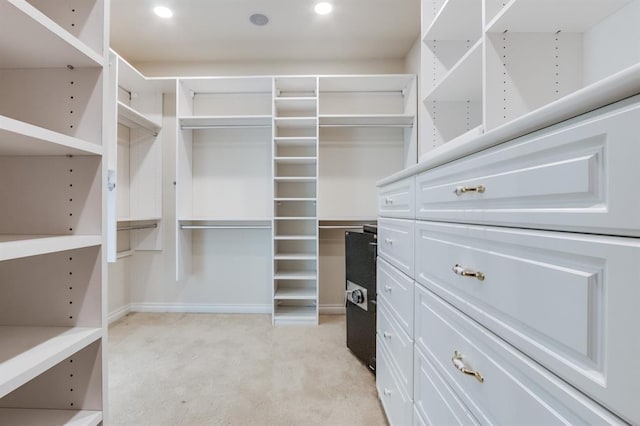 walk in closet featuring light carpet