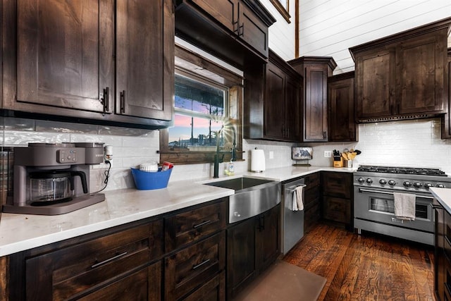 kitchen with appliances with stainless steel finishes, sink, premium range hood, dark hardwood / wood-style floors, and dark brown cabinets