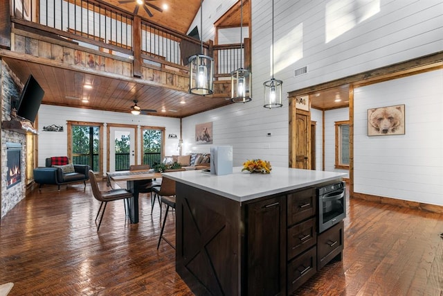 kitchen with wooden ceiling, ceiling fan, decorative light fixtures, a fireplace, and a center island