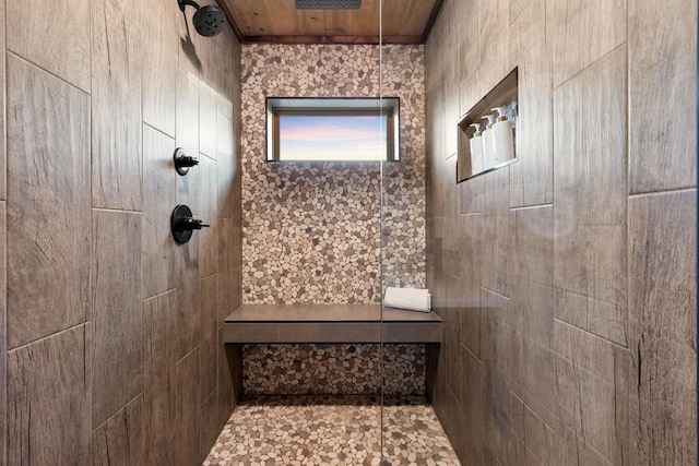 bathroom featuring tiled shower and wood ceiling