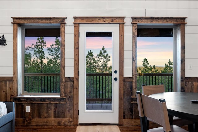 doorway to outside featuring wood walls and hardwood / wood-style flooring