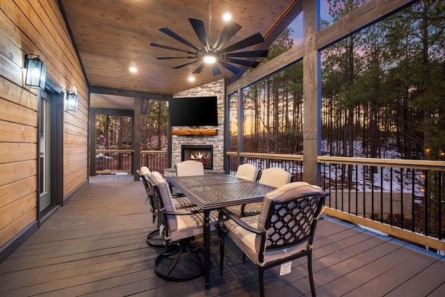 wooden terrace with ceiling fan and an outdoor stone fireplace