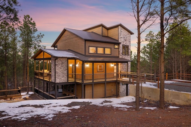 snow covered house featuring a garage