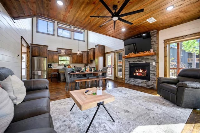 living room featuring ceiling fan, a fireplace, wood ceiling, and dark hardwood / wood-style floors