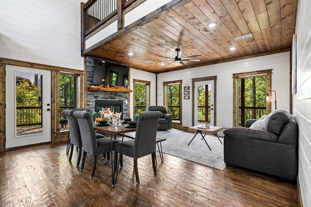 dining room with dark hardwood / wood-style floors, ceiling fan, wooden ceiling, and a fireplace