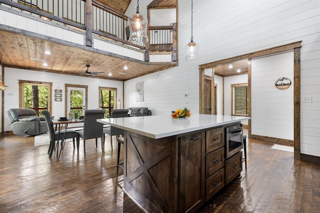 kitchen featuring a high ceiling, dark hardwood / wood-style flooring, decorative light fixtures, and ceiling fan