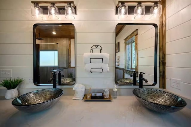 bathroom with wooden walls and sink