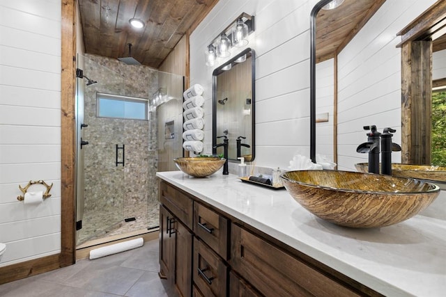 bathroom featuring wood walls, vanity, wooden ceiling, and a shower with shower door