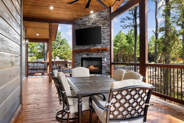 wooden terrace with ceiling fan and an outdoor stone fireplace