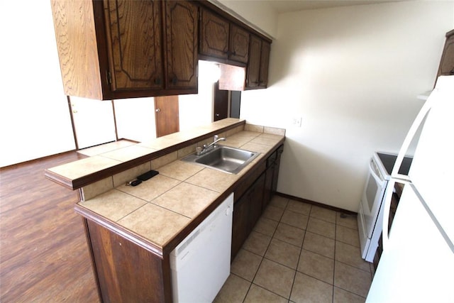 kitchen with white appliances, tile counters, sink, kitchen peninsula, and dark brown cabinets