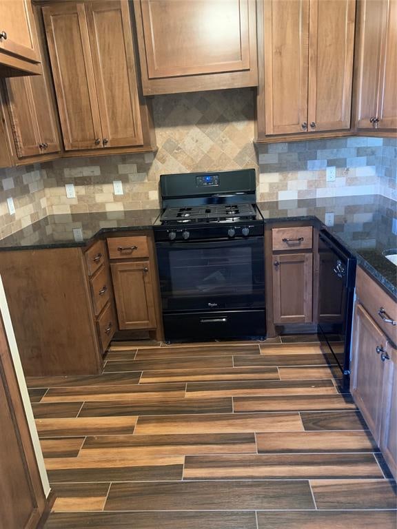 kitchen featuring dark hardwood / wood-style flooring, backsplash, and black appliances