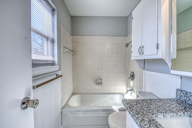 full bathroom with tiled shower / bath combo, toilet, and vanity