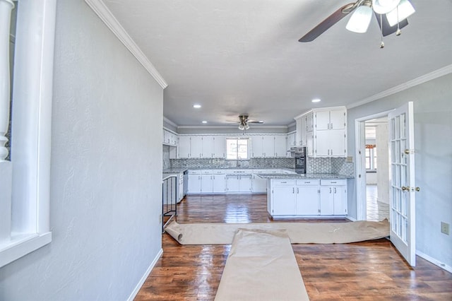 kitchen with white cabinets, decorative backsplash, dark wood-type flooring, and a healthy amount of sunlight