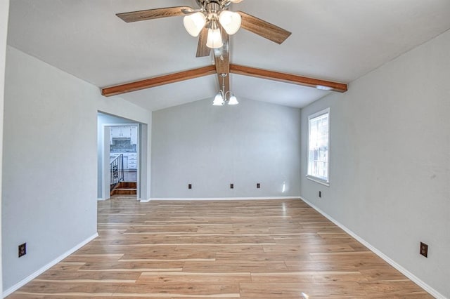 spare room with ceiling fan with notable chandelier, vaulted ceiling with beams, and light hardwood / wood-style floors