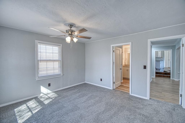 unfurnished bedroom with carpet flooring, ceiling fan, and a textured ceiling