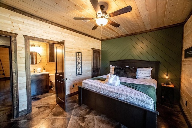 bedroom with wooden walls, wooden ceiling, connected bathroom, and ceiling fan