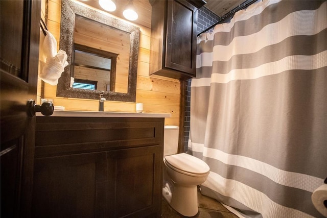 bathroom featuring vanity, wood walls, and toilet