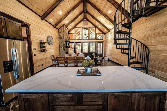 kitchen featuring wooden walls, wood ceiling, light stone countertops, and stainless steel refrigerator with ice dispenser