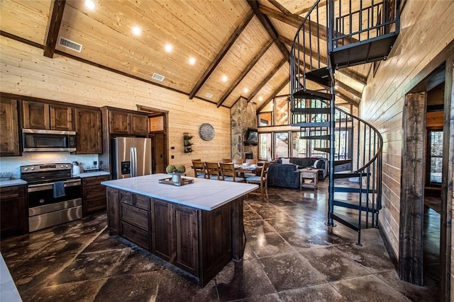 kitchen featuring a kitchen island, wooden walls, stainless steel appliances, and wood ceiling