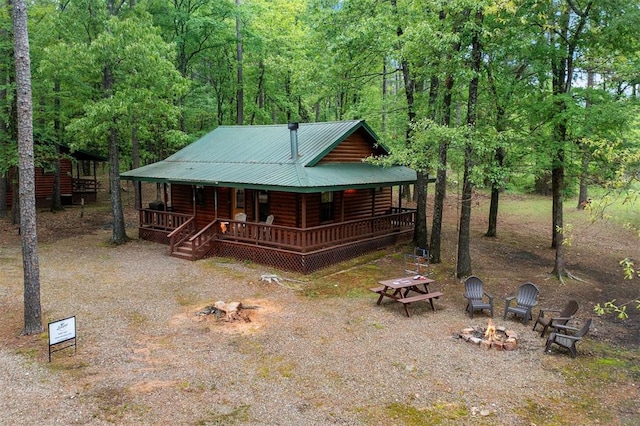 log cabin with a porch and a fire pit