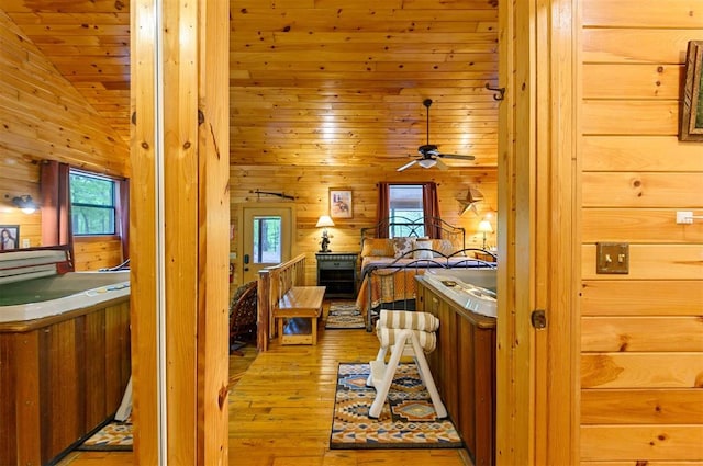 bedroom featuring light hardwood / wood-style floors, lofted ceiling, wooden walls, and wooden ceiling