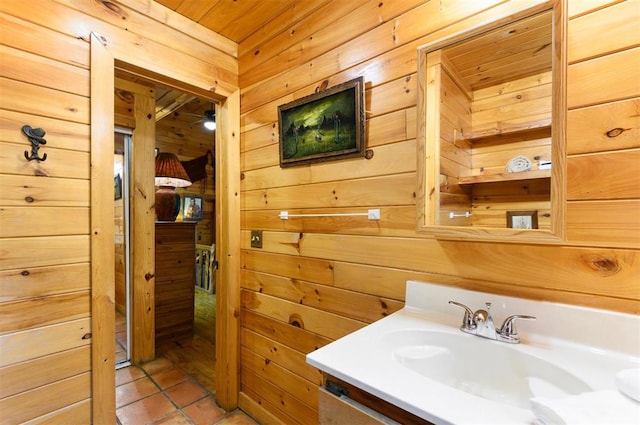 bathroom featuring tile patterned floors, wooden walls, vanity, and wood ceiling