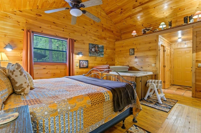 bedroom with ceiling fan, high vaulted ceiling, light hardwood / wood-style flooring, wooden ceiling, and wood walls