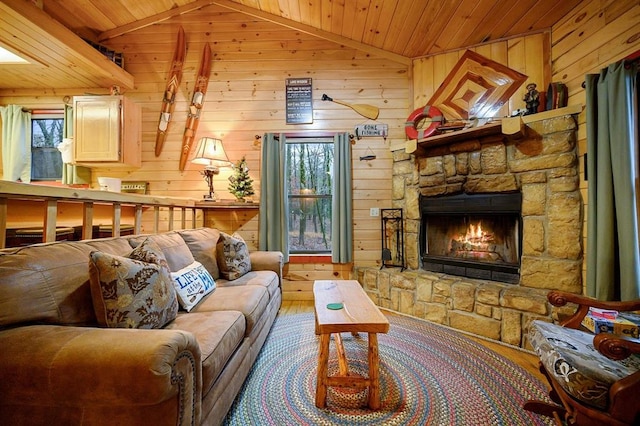 living room featuring vaulted ceiling, wood-type flooring, wooden ceiling, a stone fireplace, and wood walls