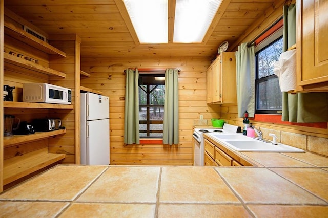 kitchen featuring wood walls, white appliances, sink, tile counters, and wood ceiling