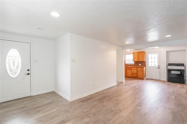 entryway featuring a textured ceiling and light hardwood / wood-style floors