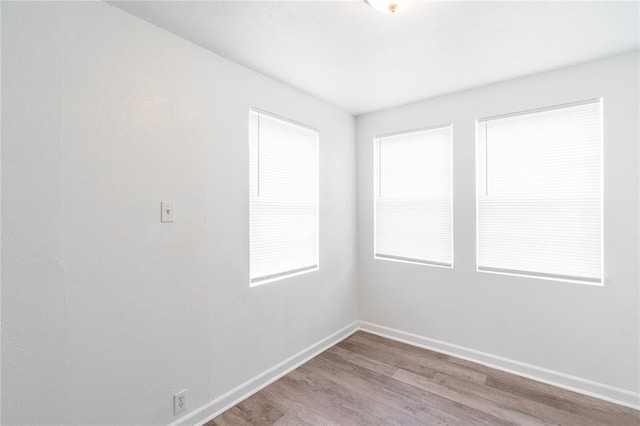 spare room featuring light hardwood / wood-style floors and a healthy amount of sunlight