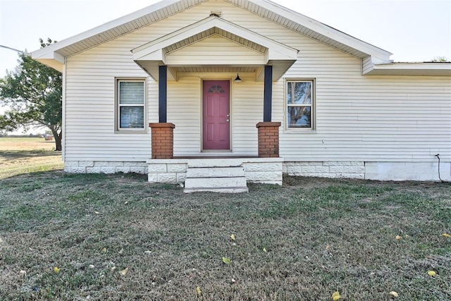 bungalow-style home with a front yard