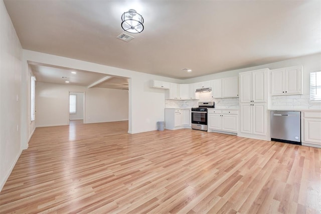 kitchen featuring white cabinets, backsplash, stainless steel appliances, and light hardwood / wood-style flooring