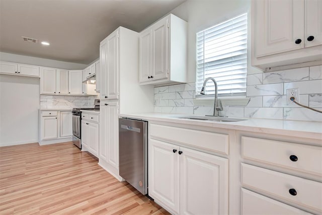 kitchen with white cabinets, backsplash, sink, and appliances with stainless steel finishes