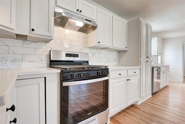 kitchen featuring backsplash, white cabinetry, stainless steel appliances, and light hardwood / wood-style floors