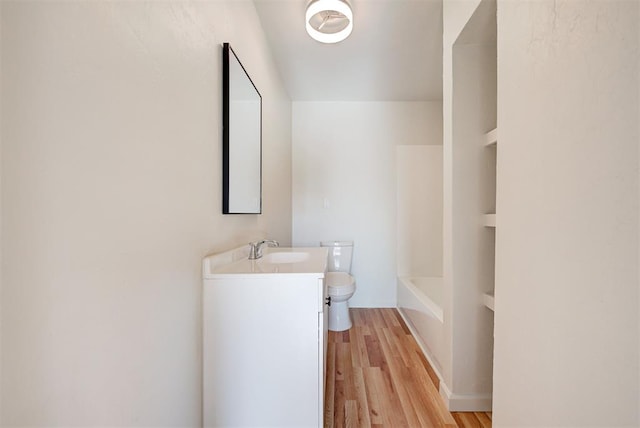 bathroom featuring vanity, wood-type flooring, and toilet