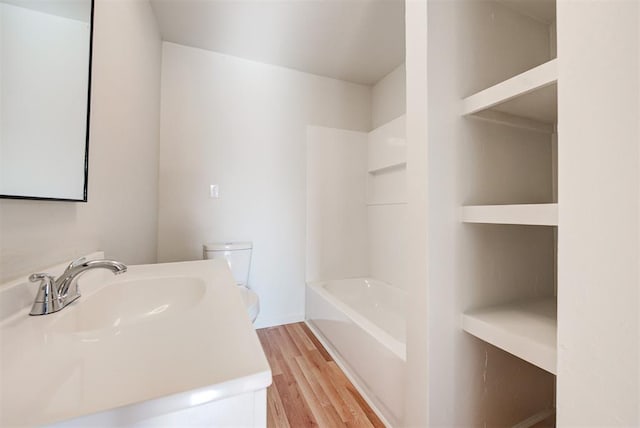 bathroom with hardwood / wood-style flooring, toilet, and sink