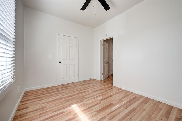 empty room with ceiling fan and light hardwood / wood-style flooring