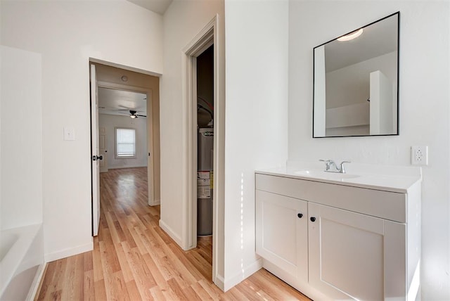 bathroom featuring wood-type flooring, vanity, ceiling fan, and water heater