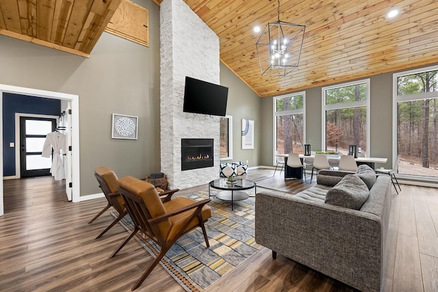 living room with dark hardwood / wood-style flooring, a stone fireplace, wooden ceiling, and high vaulted ceiling