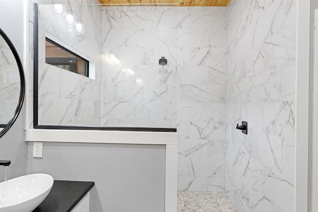 bathroom with vanity and a tile shower