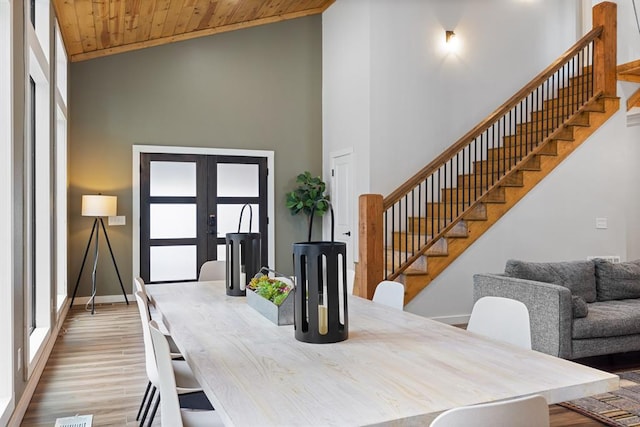 dining area featuring wooden ceiling, light hardwood / wood-style flooring, high vaulted ceiling, and french doors