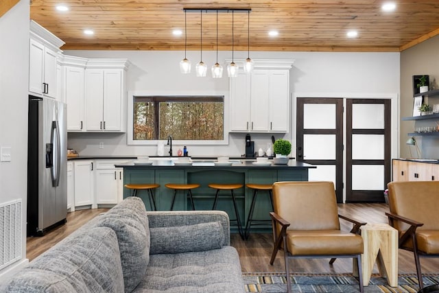 kitchen featuring white cabinetry, stainless steel fridge with ice dispenser, wood ceiling, and decorative light fixtures