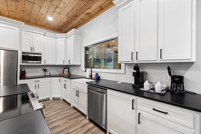 kitchen featuring appliances with stainless steel finishes, sink, light hardwood / wood-style flooring, wooden ceiling, and white cabinetry