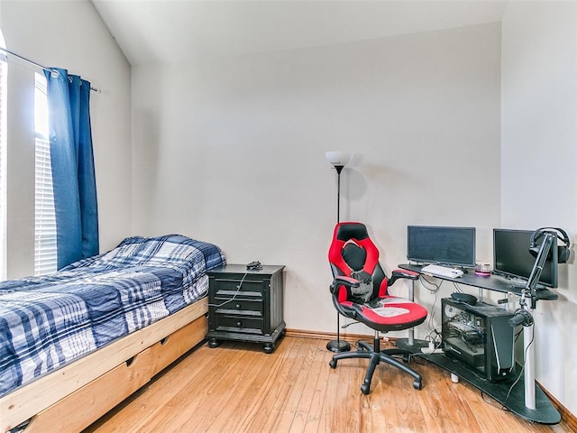 bedroom with wood-type flooring and lofted ceiling